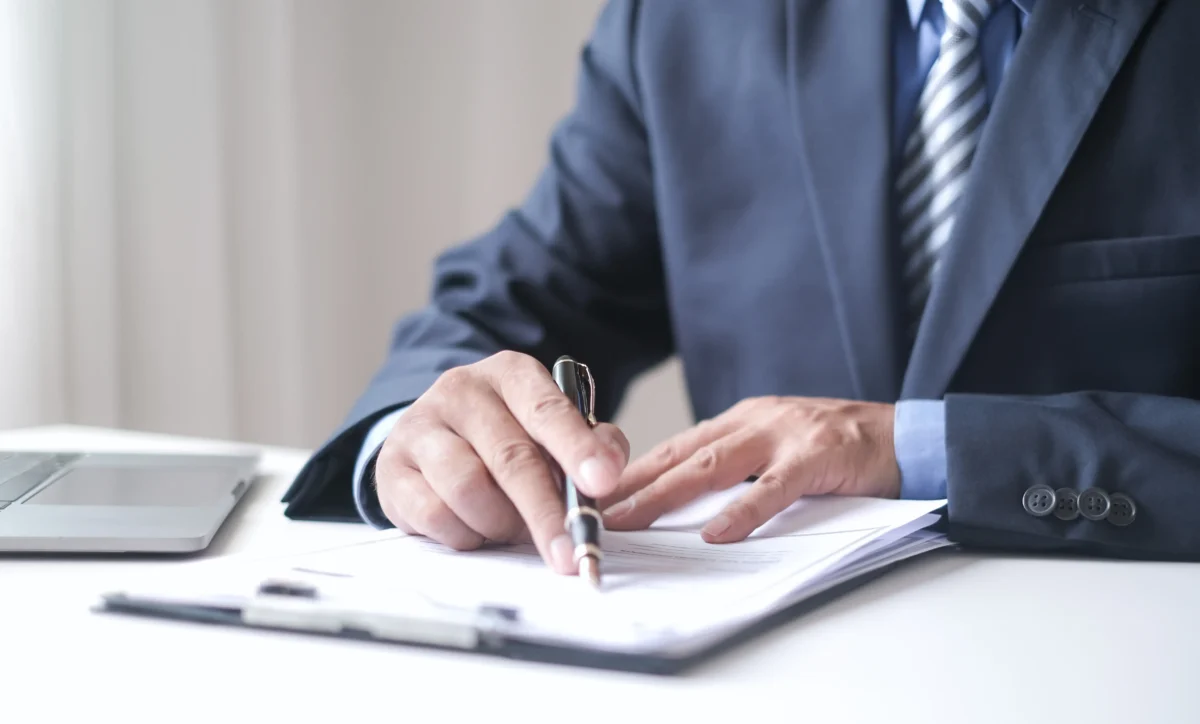 Výši starobního důchodu ovlivňuje plat v minulosti. Zdroj: Shutterstock | TVGURU.cz Ruka podepisující dokumenty.
