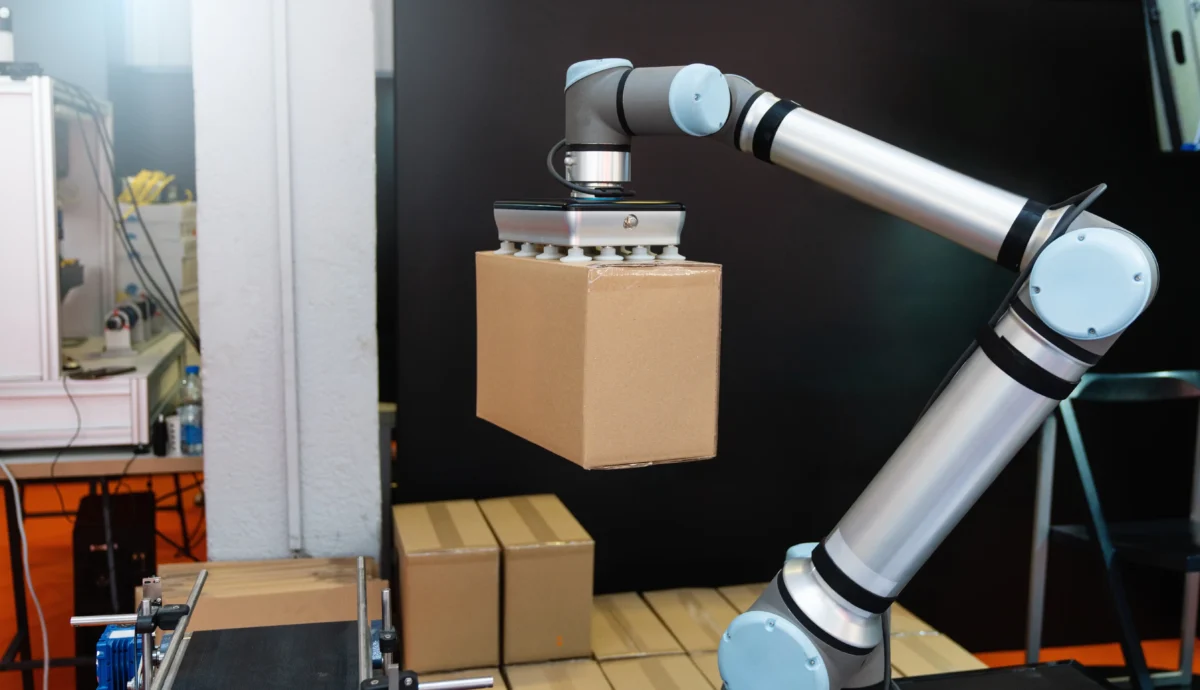 Robot zvedá balík. 