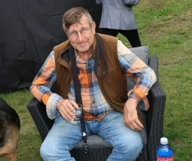 Václav Vydra sedí venku na židli.