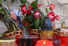 Kolem fotky Karla Gotta leží květiny a svíčky.