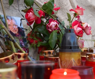 Kolem fotky Karla Gotta leží květiny a svíčky.