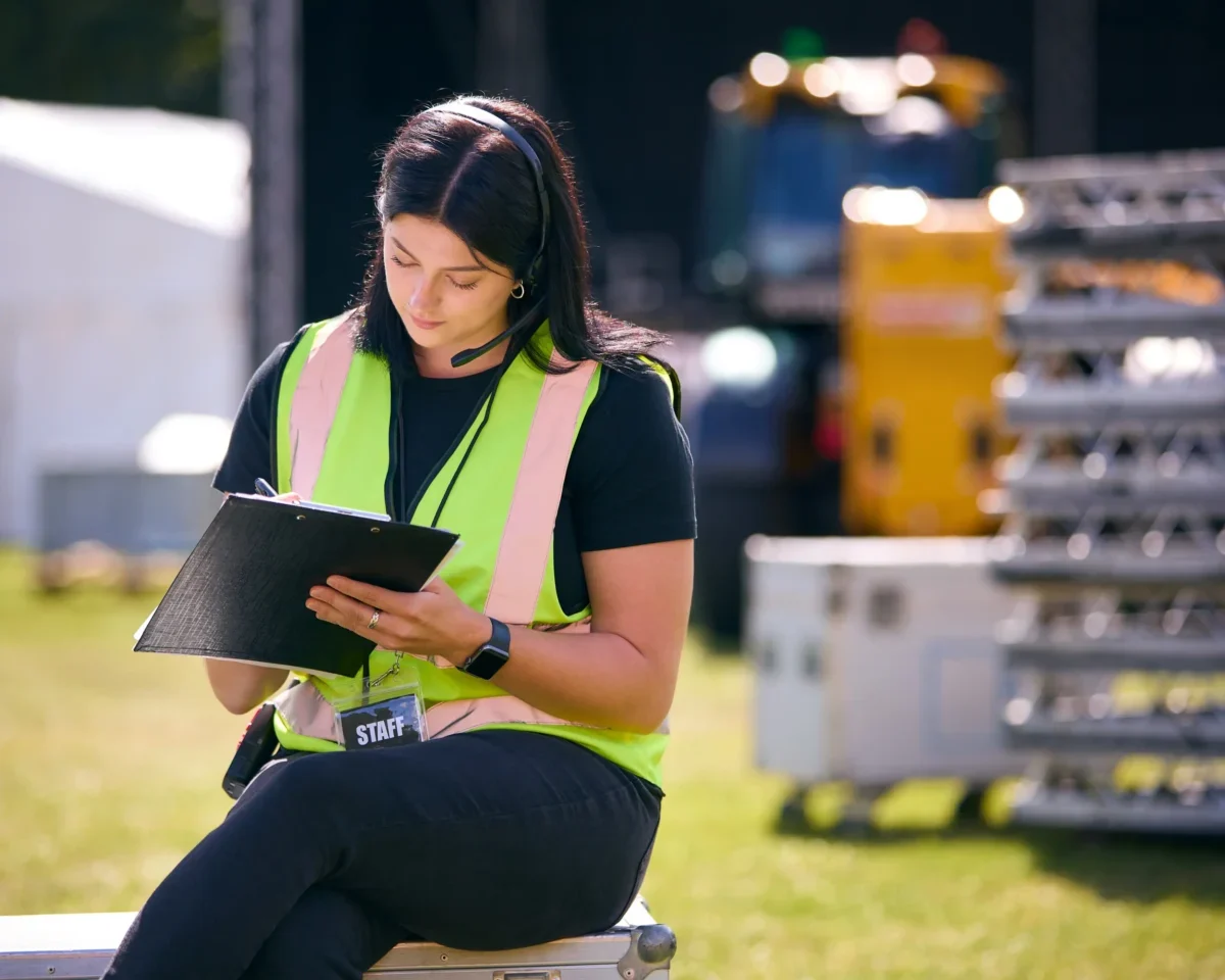 Žena s vestou si něco zapisuje.