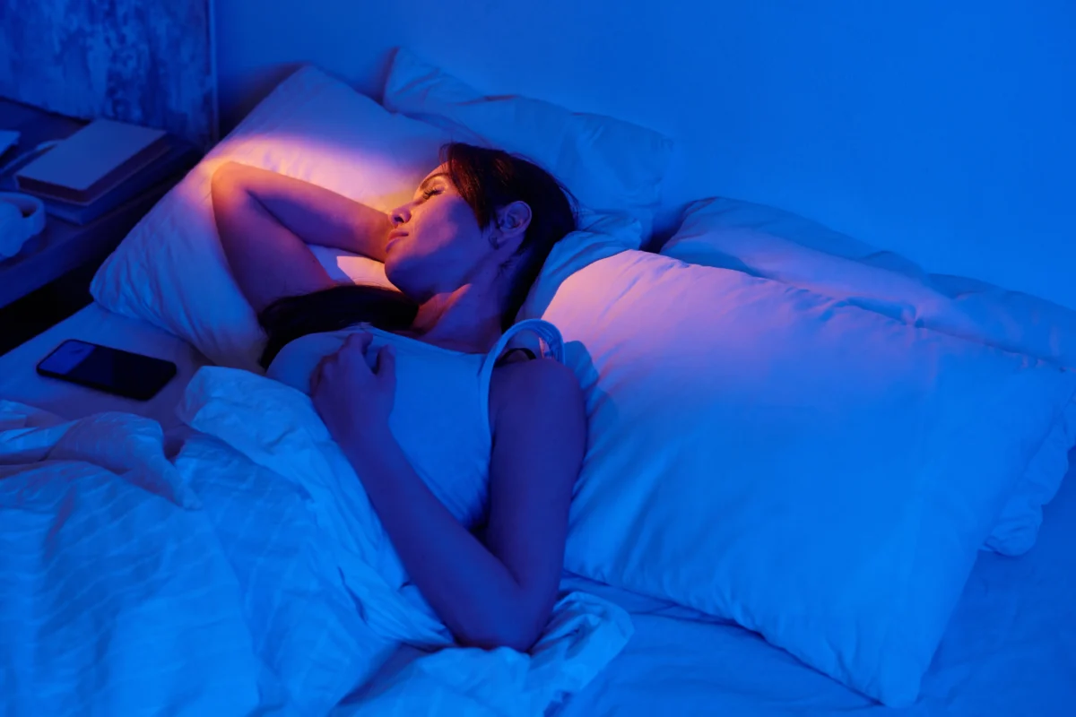 Žena leží na posteli. 