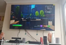 televize hraje na stěně