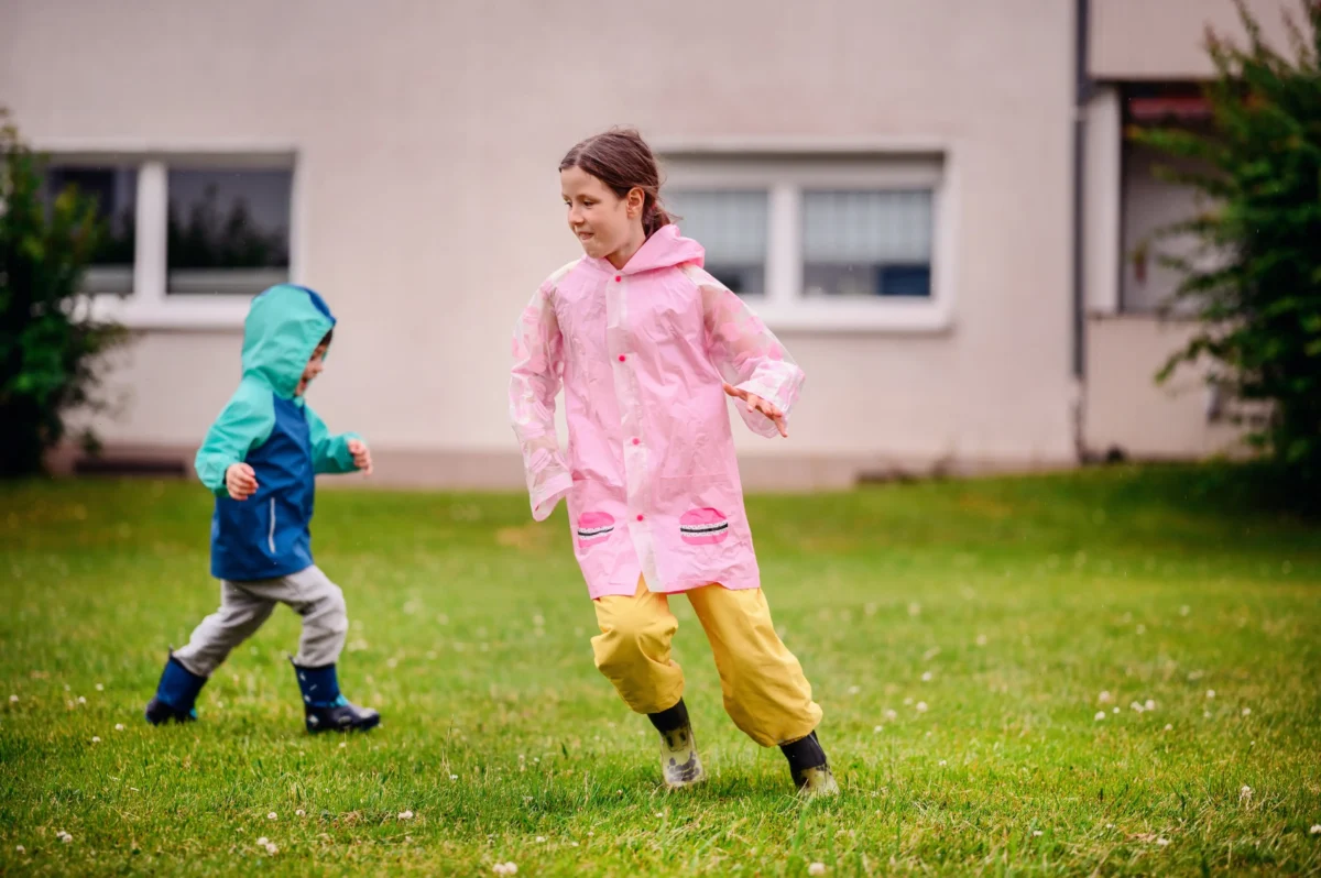 Děti pobíhající v pláštěnkách.