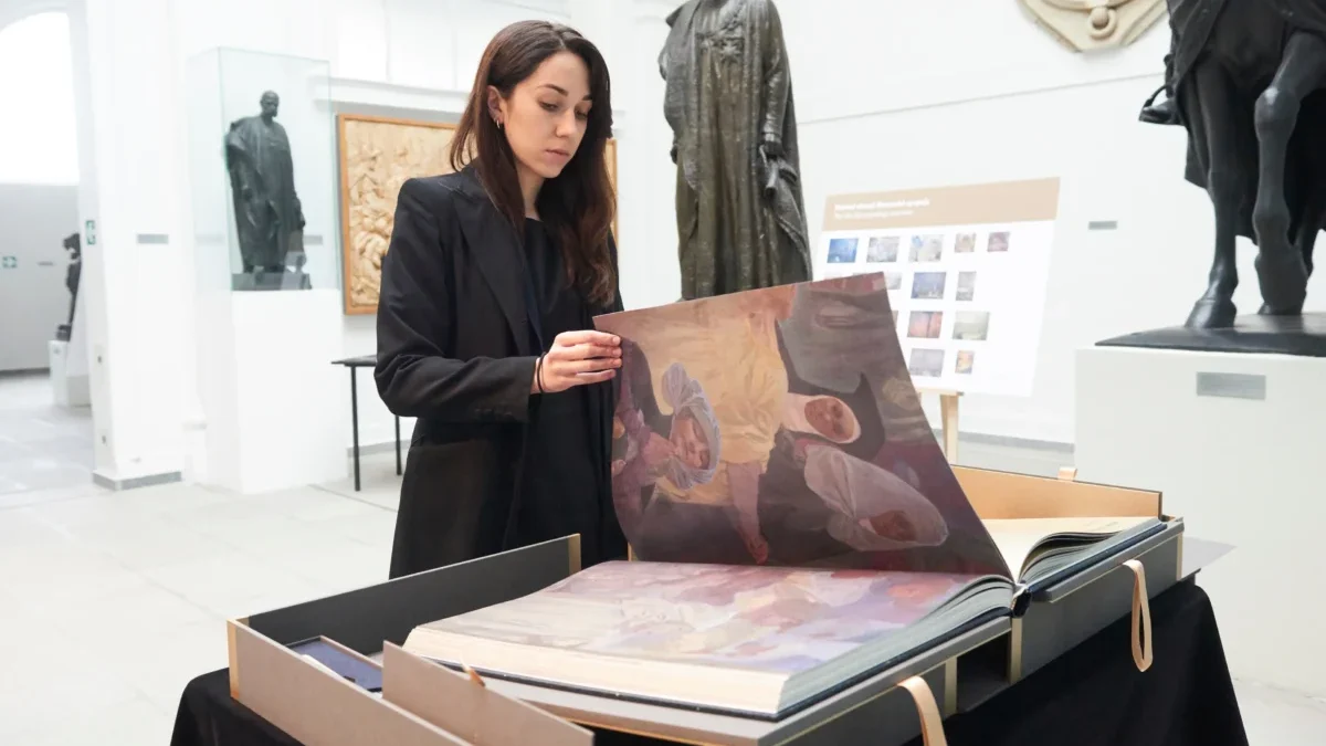 Žena listuje obří knihou.