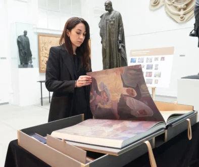 Žena listuje obří knihou.