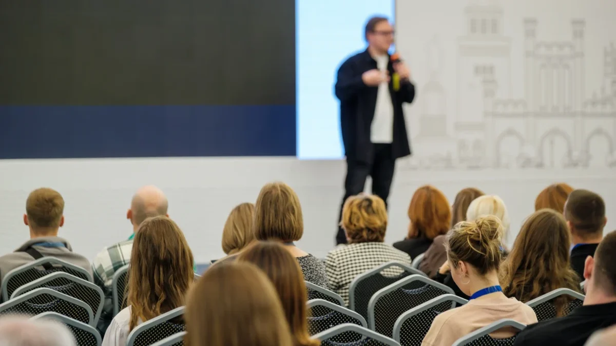 Muž mluví na konferenci.