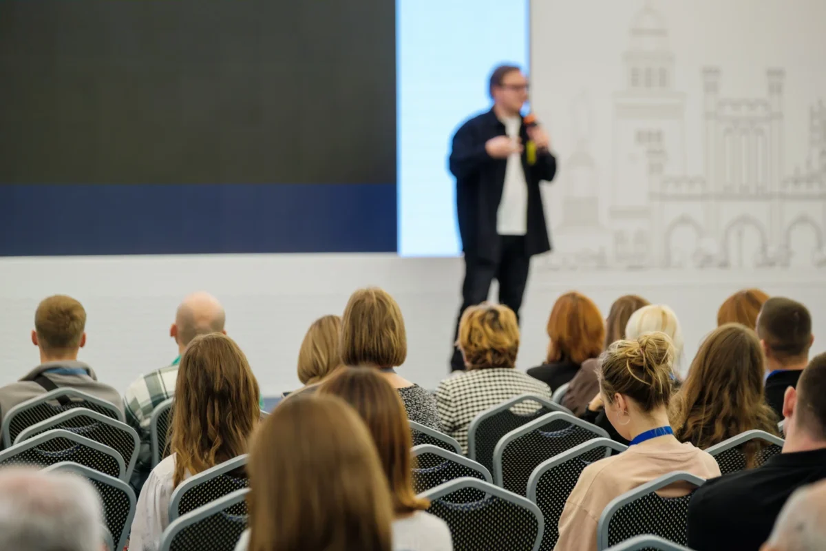 Muž mluví na konferenci.