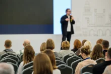 Muž mluví na konferenci.