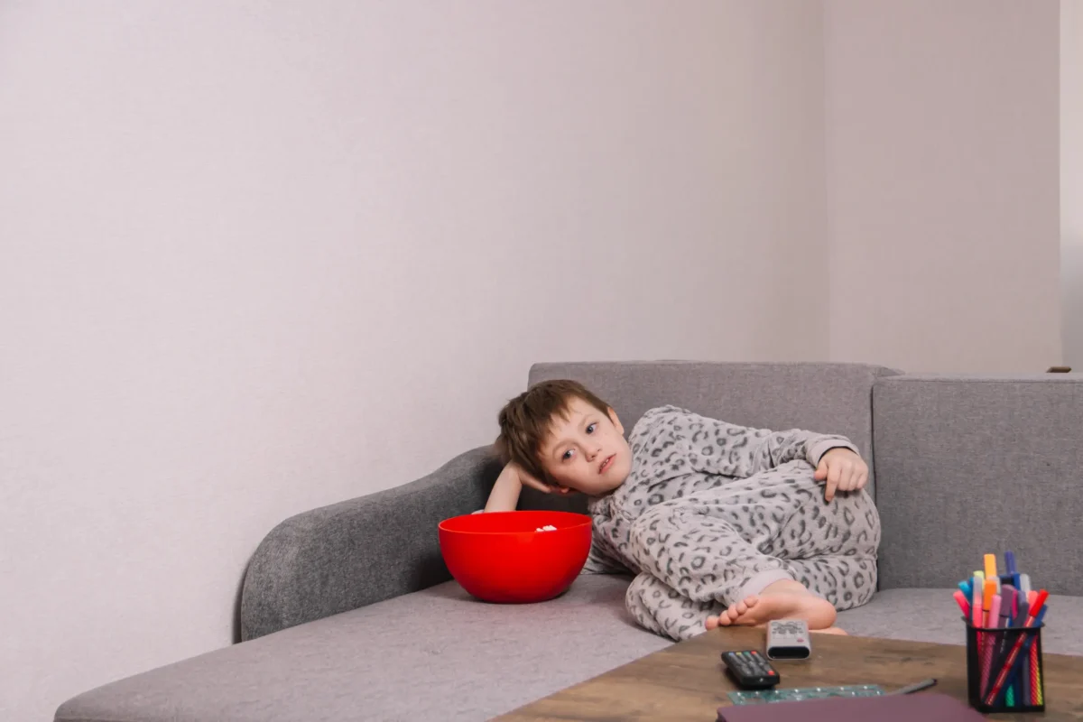 Chlapec leží na gauči. 