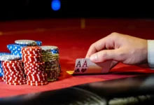 Muž odkrývá karty na pokerovém stole s žetony