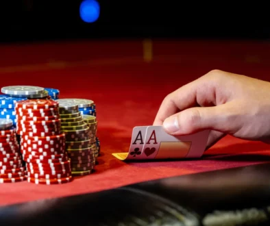 Muž odkrývá karty na pokerovém stole s žetony