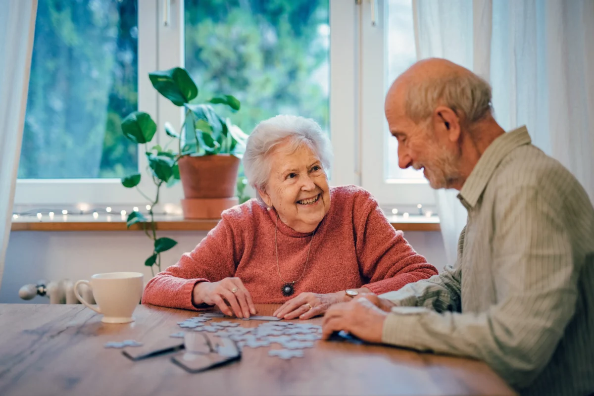 Babička s dědou sedí u stolu.