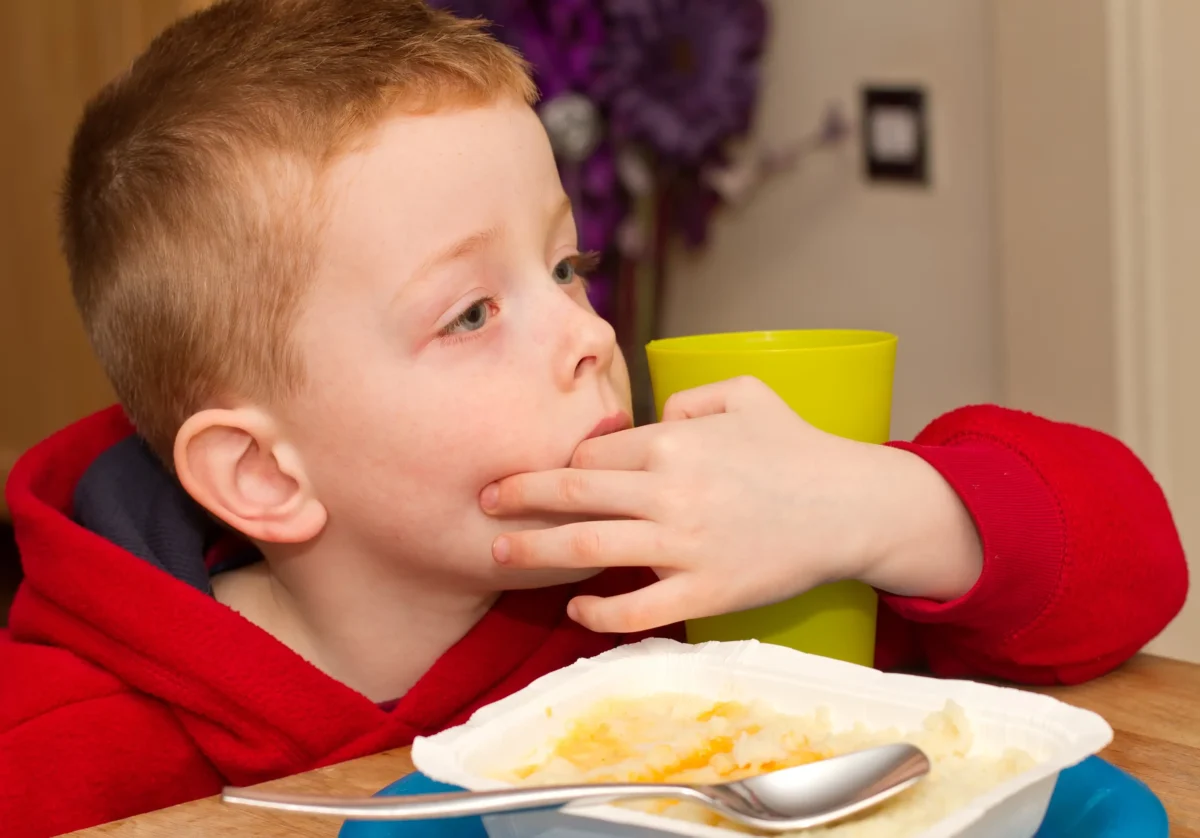 Chlapec sedí u talíře.