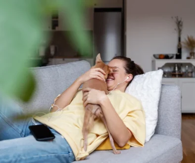 Žena s kočkou leží na pohovce.