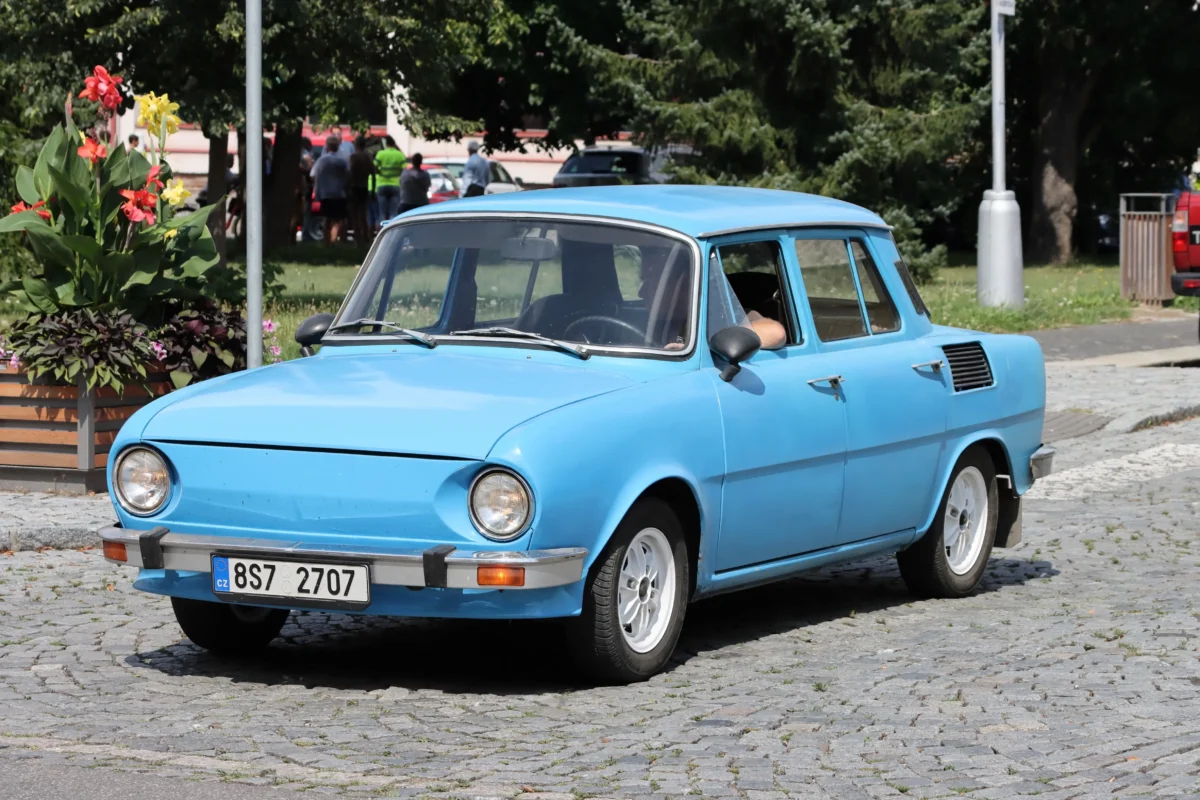 Na silnici je staré modré auto. 