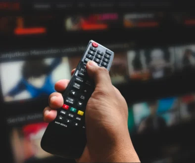 Člověk ovladačem míří na TV.