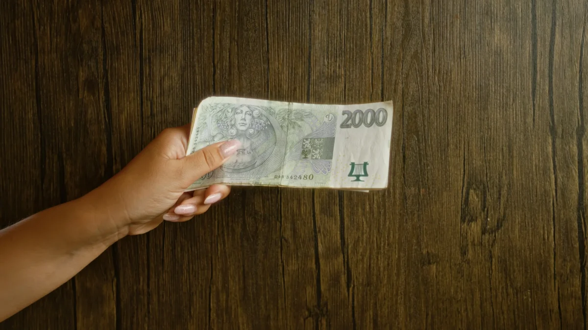 Žena v ruce drží 2 000 Kč.