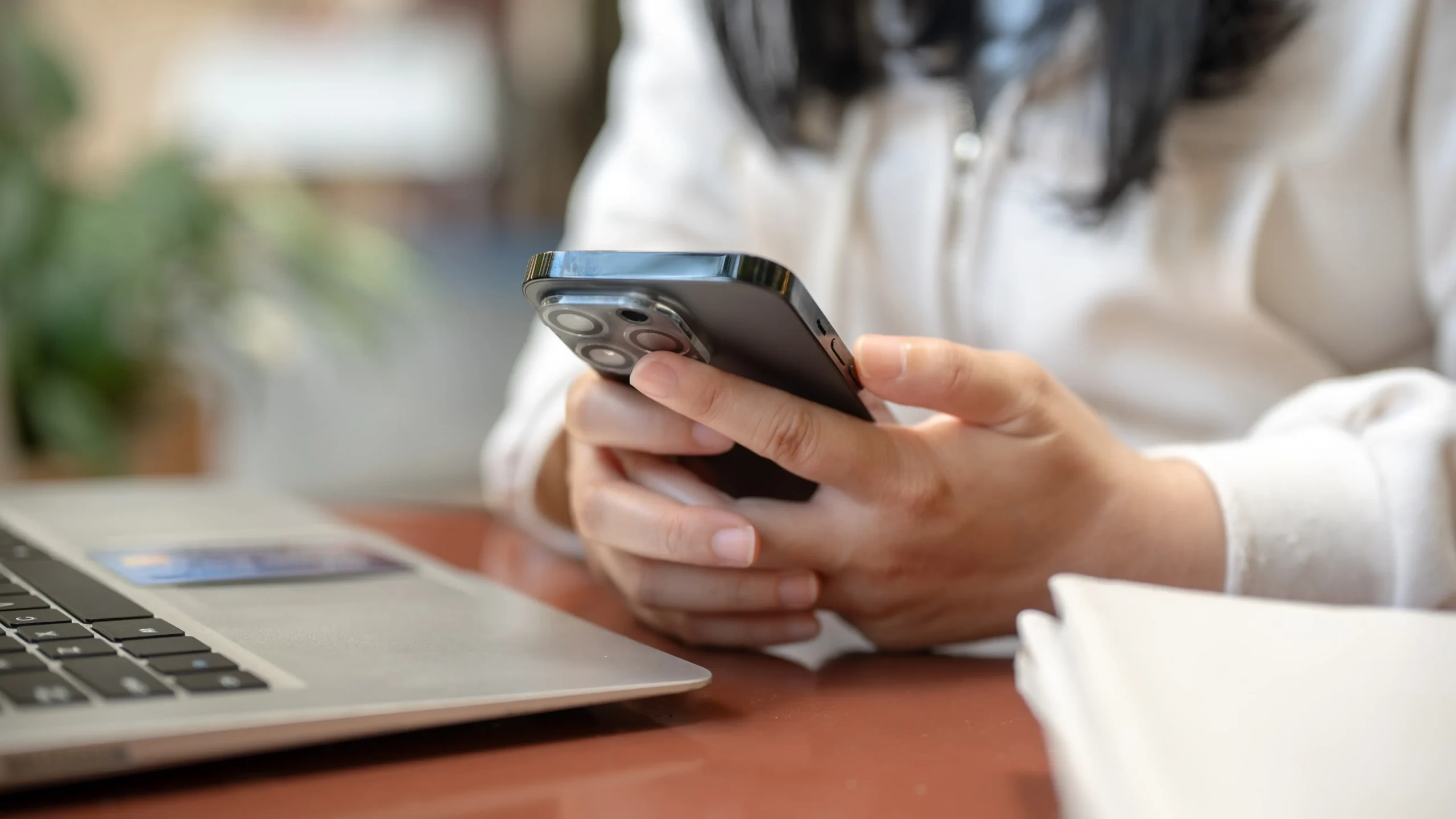 Žena drží v rukou mobilní telefon 