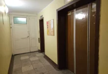 Chodba v paneláku s výtahem a nástěnkou