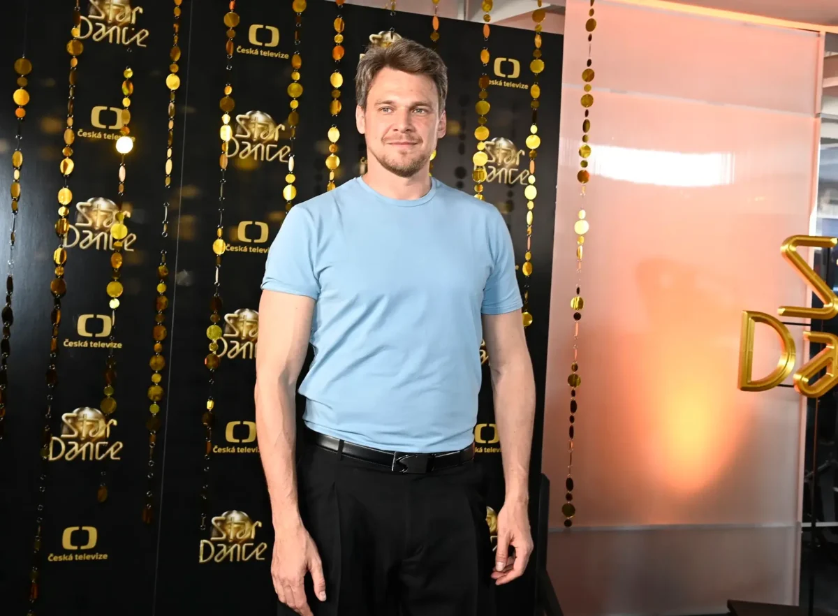 Vojtěch Dyk stojí u nápisů StarDance.