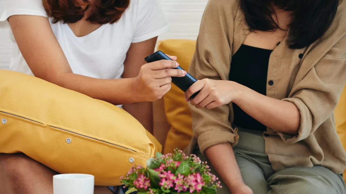 Ženy si podávají TV ovladač.