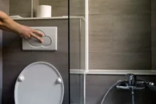 Člověk splachuje toaletu.