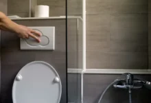 Člověk splachuje toaletu.