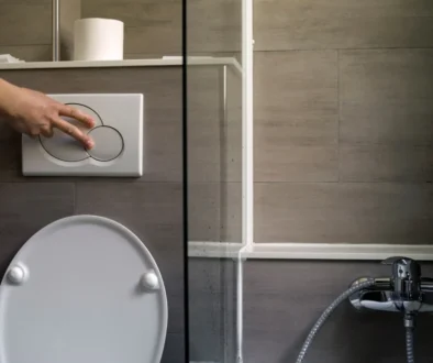 Člověk splachuje toaletu.