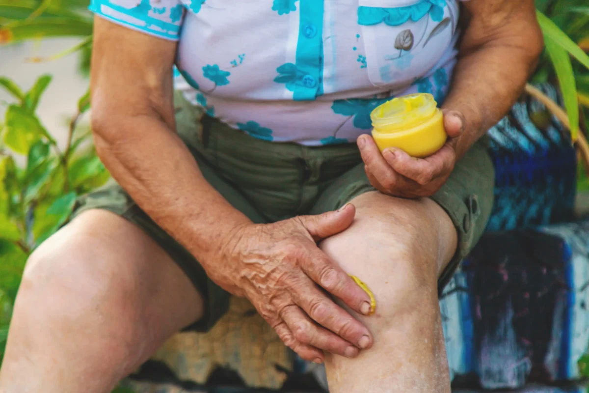 Člověk si maže koleno.