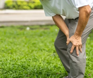 Člověk se drží za koleno.