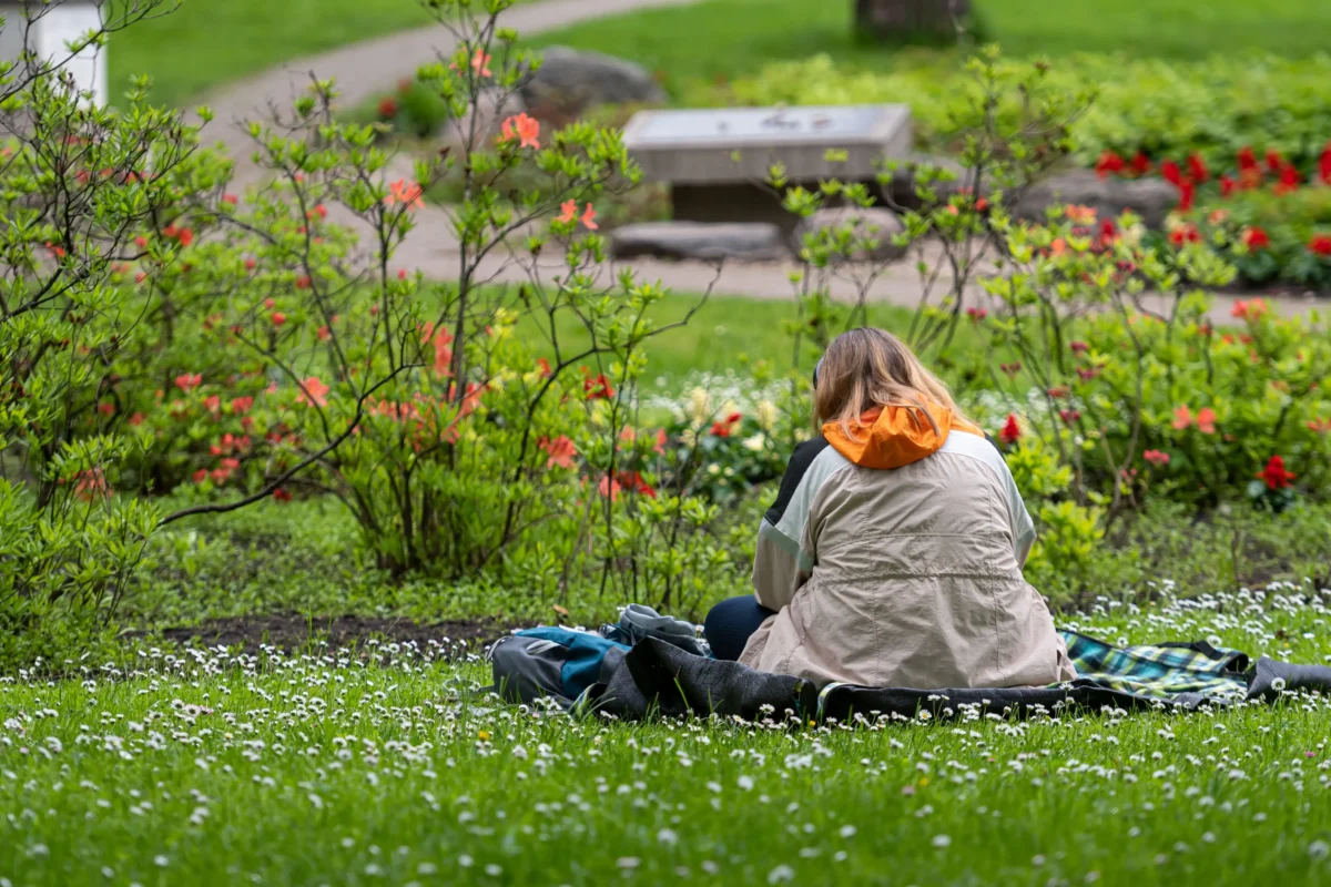 Žena sedí v parku na zemi. 