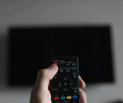 Člověk míří ovladačem na TV.