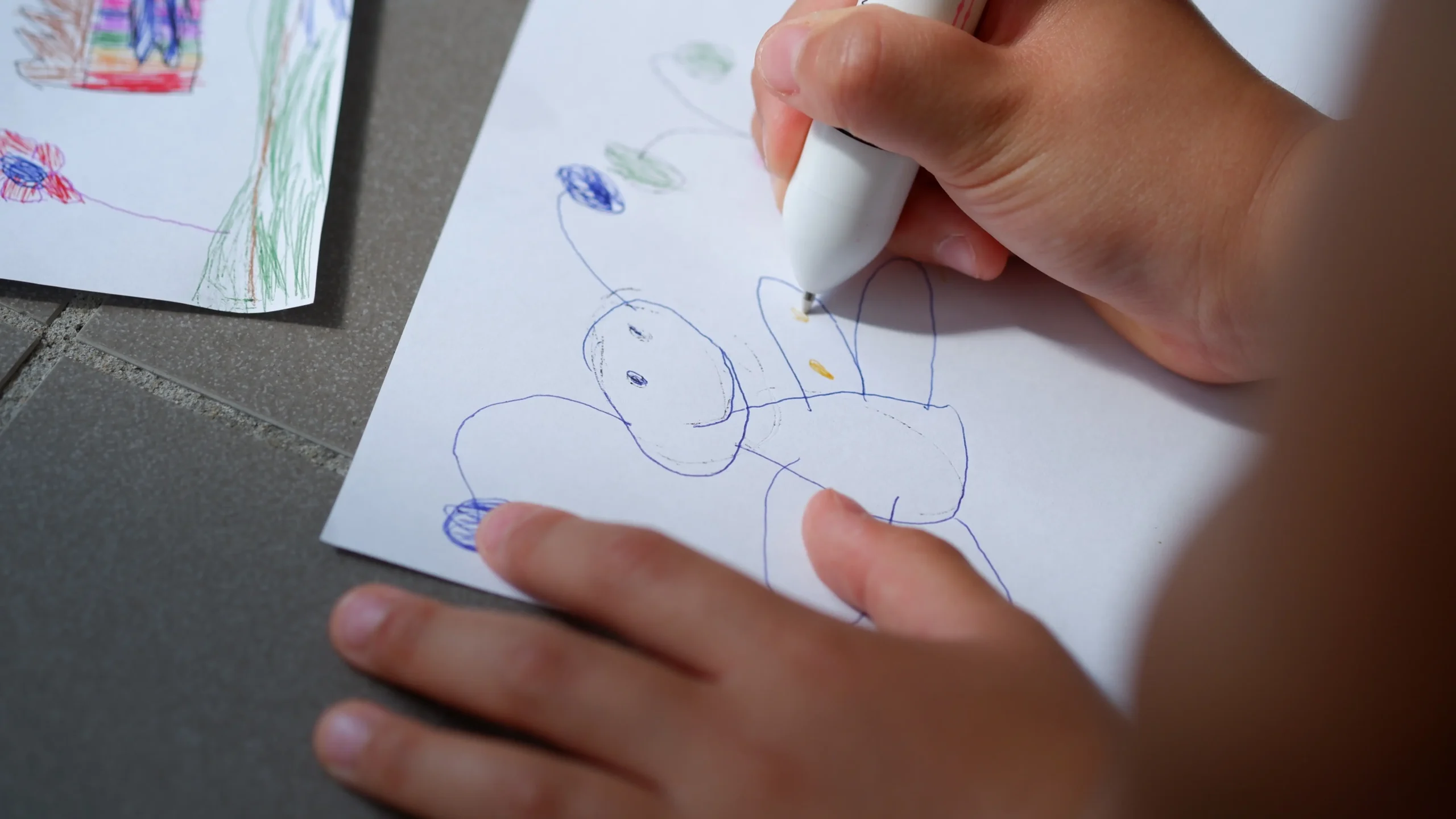 Dítě kreslí motýla na papír