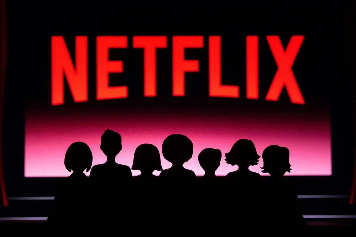 Nápis Netflix a pod ním jsou stíny lidí.