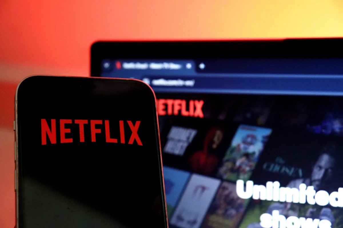 Na mobilu i notebooku je otevřený Netflix.