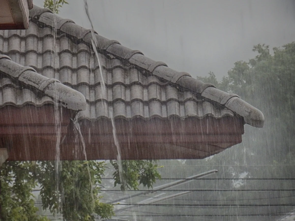 Prudký déšť nad střechou domu