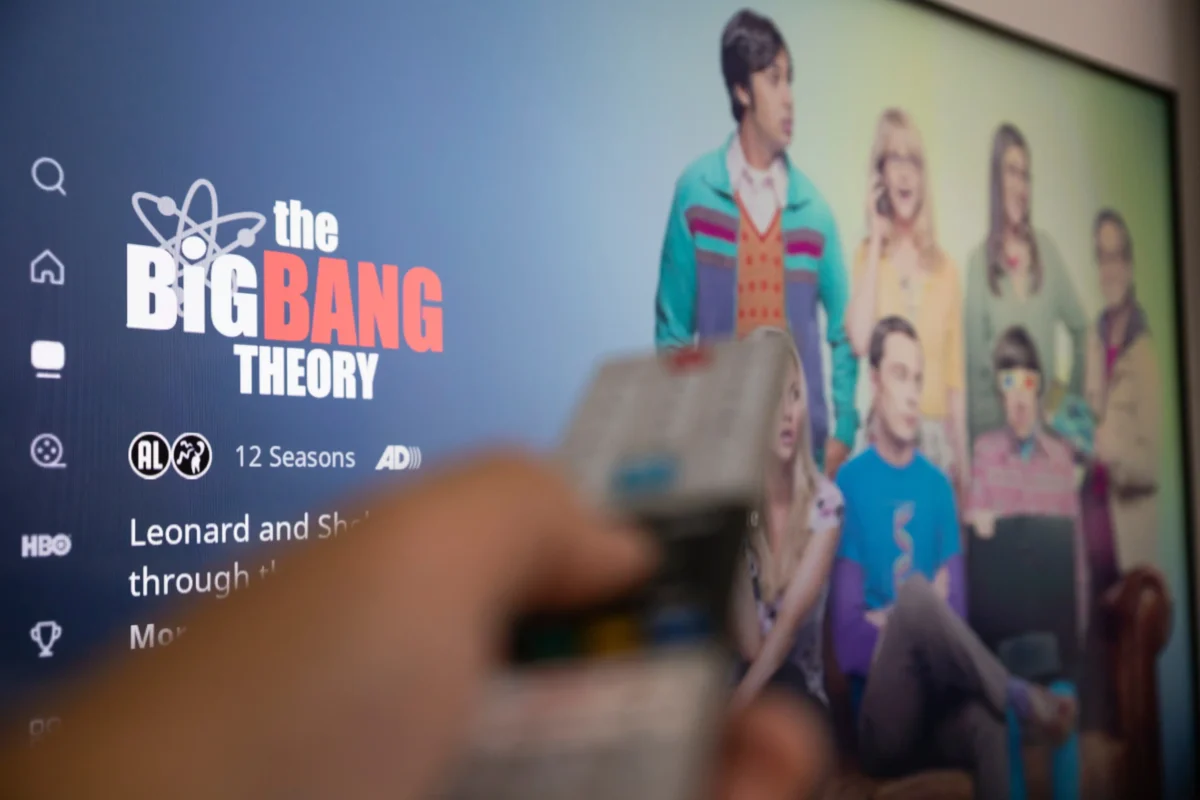 Ruka s ovladačem a Teorie velkého třesku na TV.