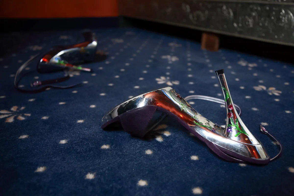 Na koberci leží střevíček. 