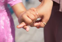 Holčička drží ženu za prst.