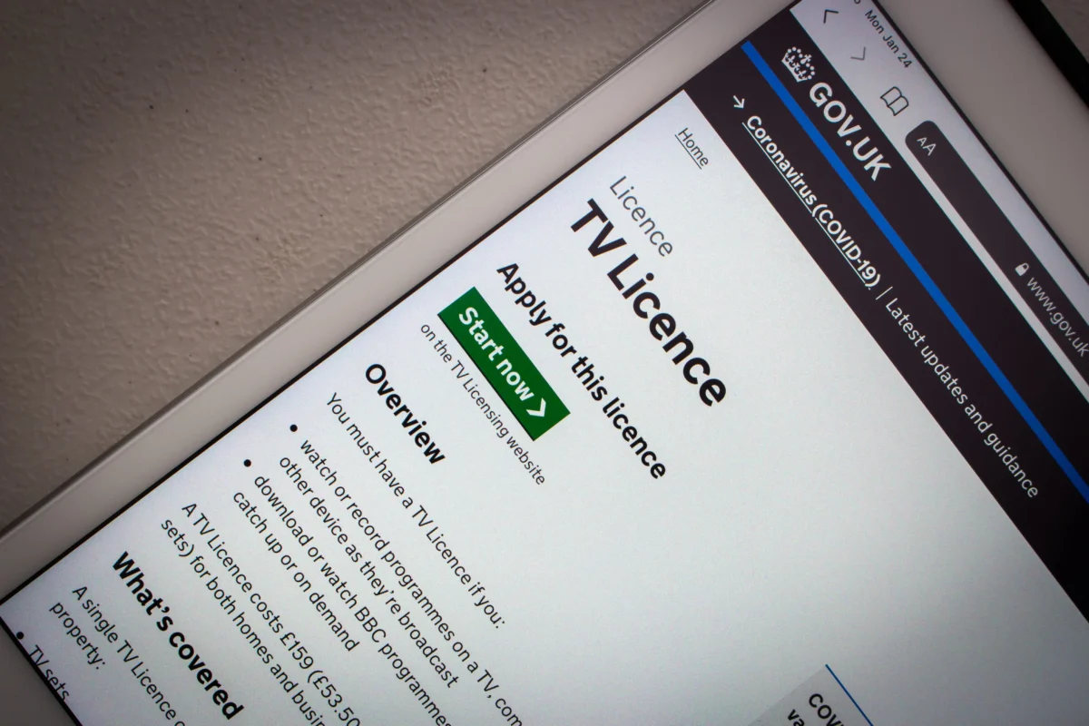 Close-up of a tilted tablet displaying the GOV.UK TV Licence page, with a green Start now button visible.