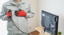 Muž v ruce drží kabel od televize.