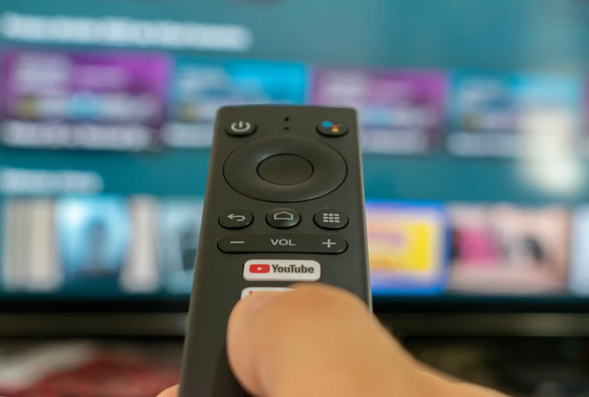Člověk v ruce drží ovladač od TV.