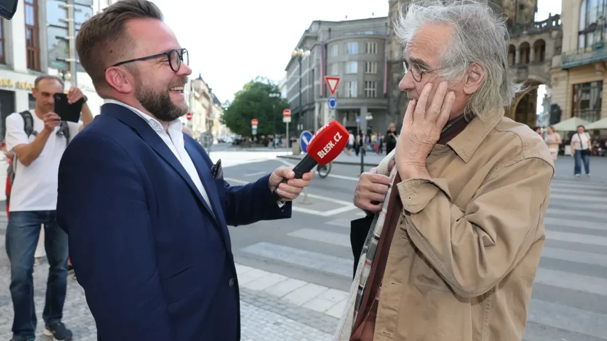 Oldřich Kaiser stojí u mikrofonu.