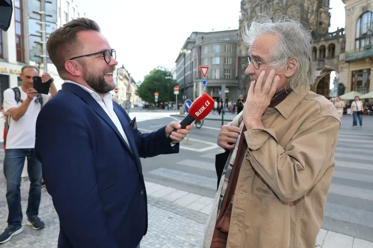 Oldřich Kaiser stojí u mikrofonu.