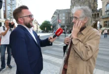 Oldřich Kaiser stojí u mikrofonu.