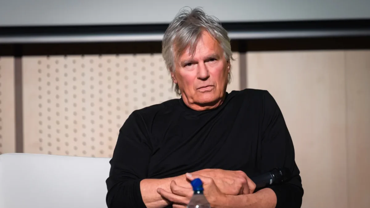 Richard Dean Anderson sedí a tváří se naštvaně.