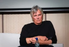 Richard Dean Anderson sedí a tváří se naštvaně.