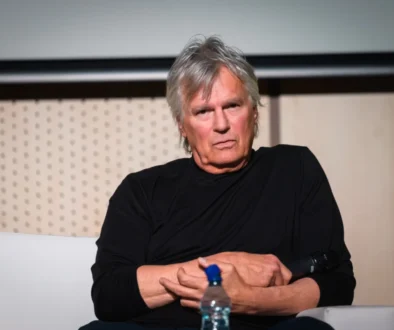 Richard Dean Anderson sedí a tváří se naštvaně.